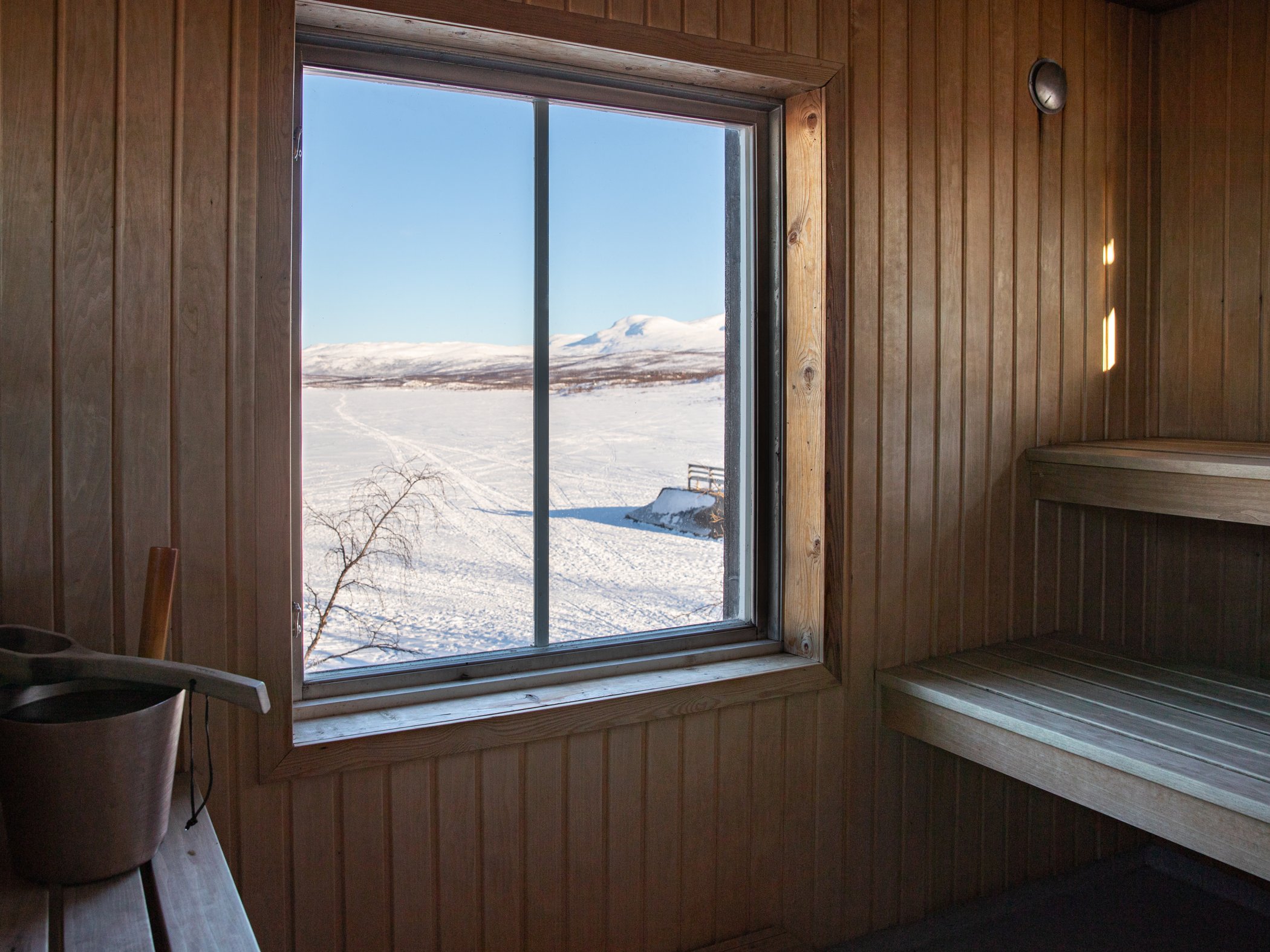 Utsikt över Torneträsk och fjällen från bastuns fönster.