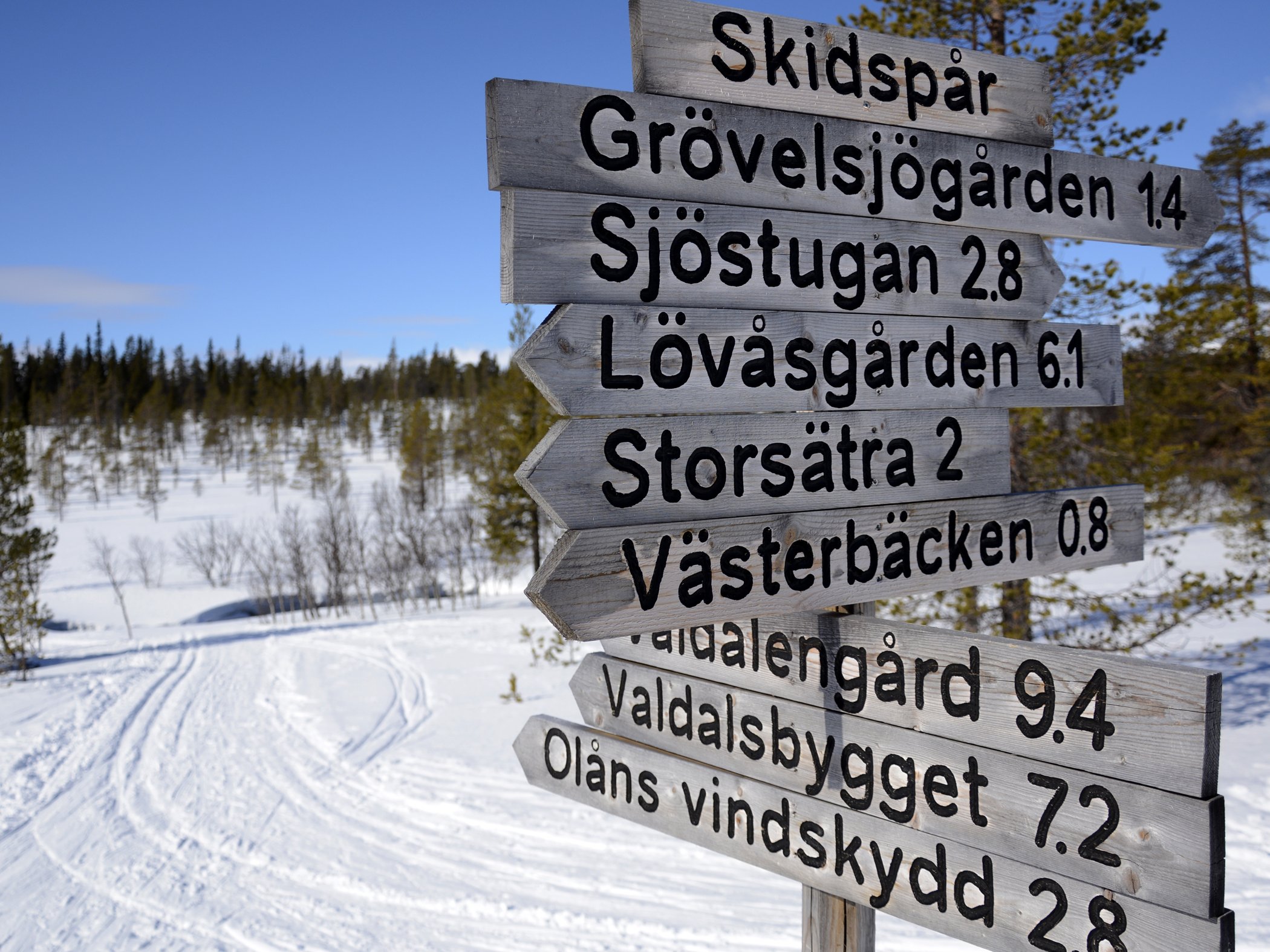 Träskyltar som visar olika längdspår.