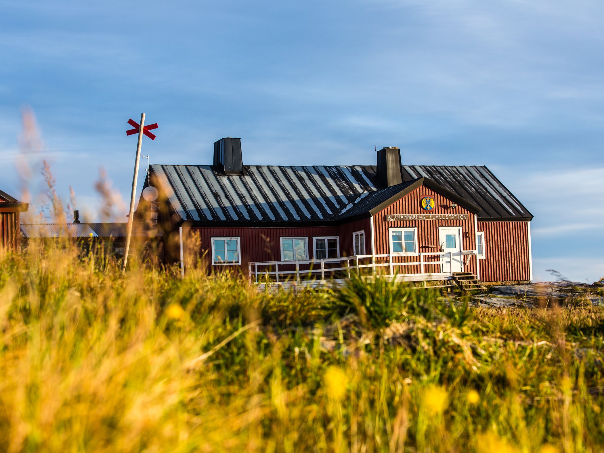 Fjällstation i kvällsljus med fjällandskap runt omkring