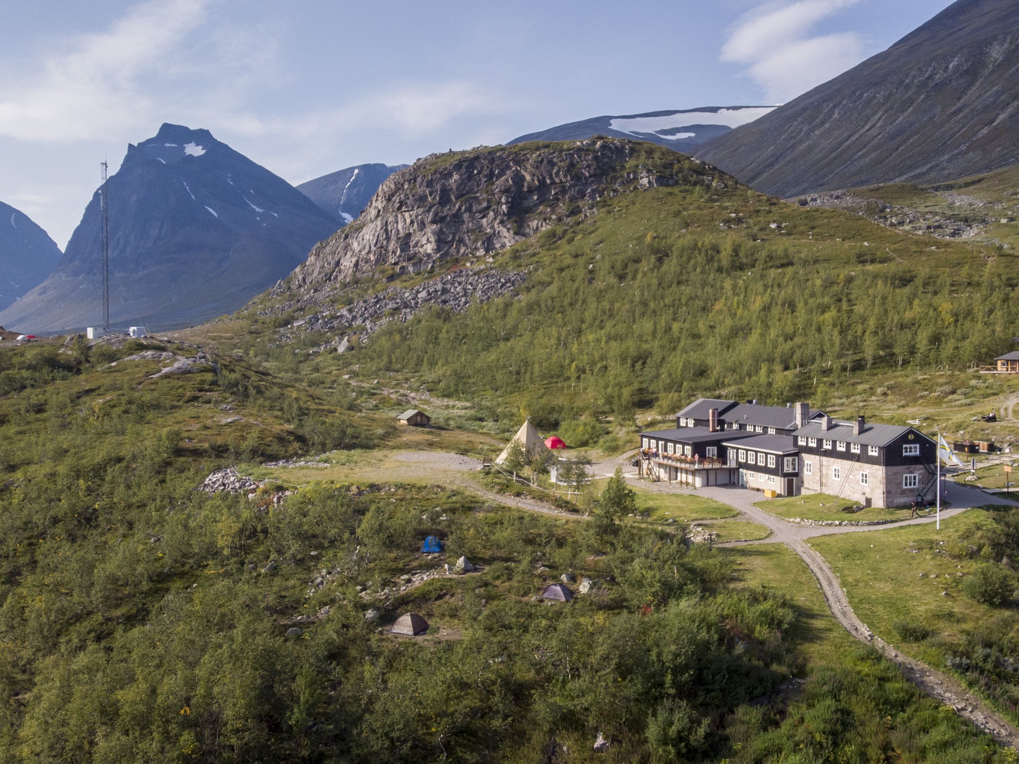 Flygbild över STF Kebnekaise Fjällstation omgiven av fjällandskap.