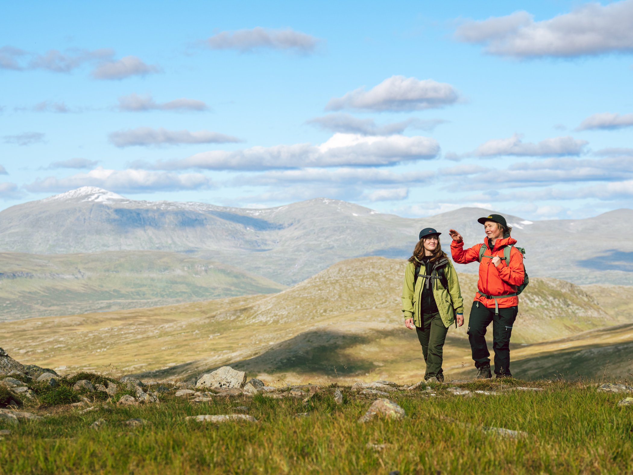 Två vandrare i öppet fjällandskap nära STF Helags fjällstation.