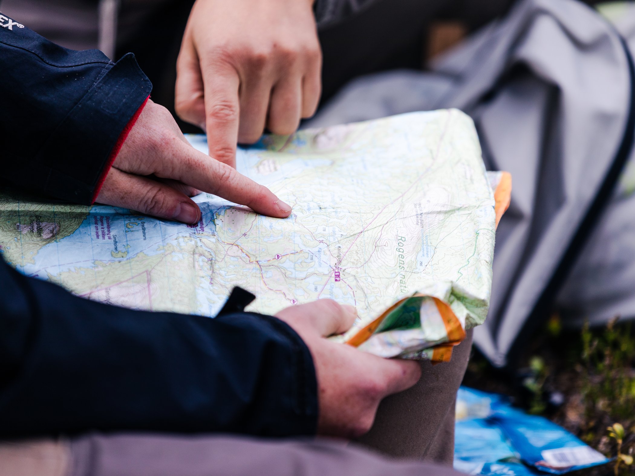 Vandrare pekar på karta under planering av fjälltur nära Grövelsjön.