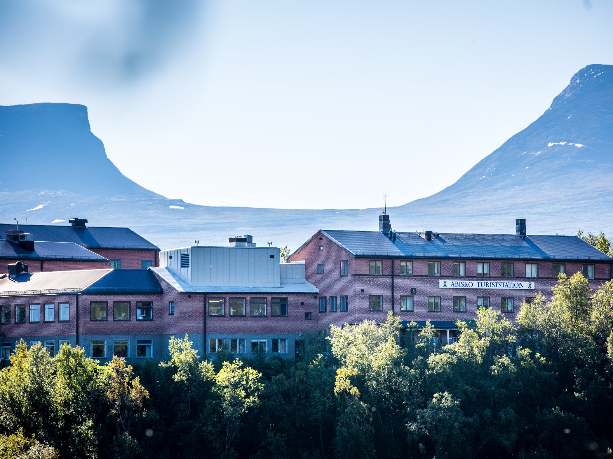 Abisko Turiststation med fjäll i bakgrunden.
