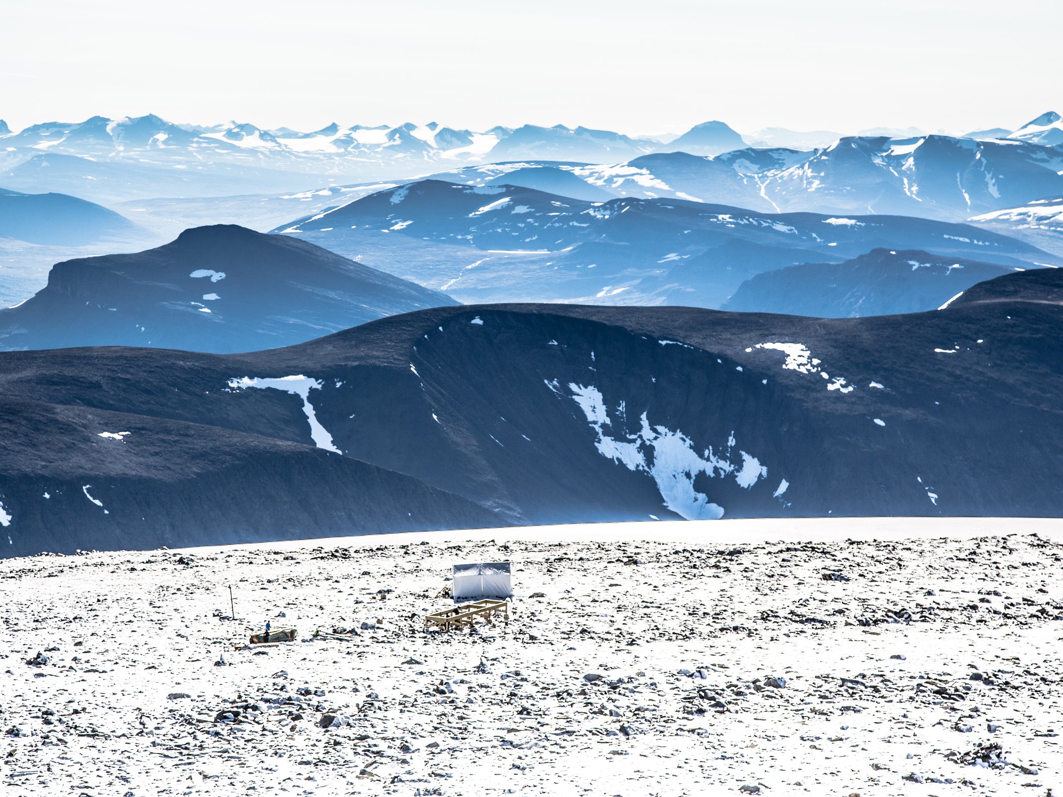 Snötäckt fjällandskap med vida vyer över berg och dalar.