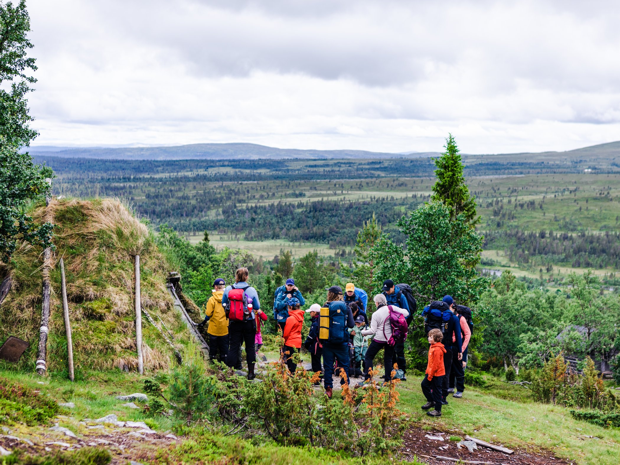Grupp vandrare tar paus med utsikt över fjällandskapet.