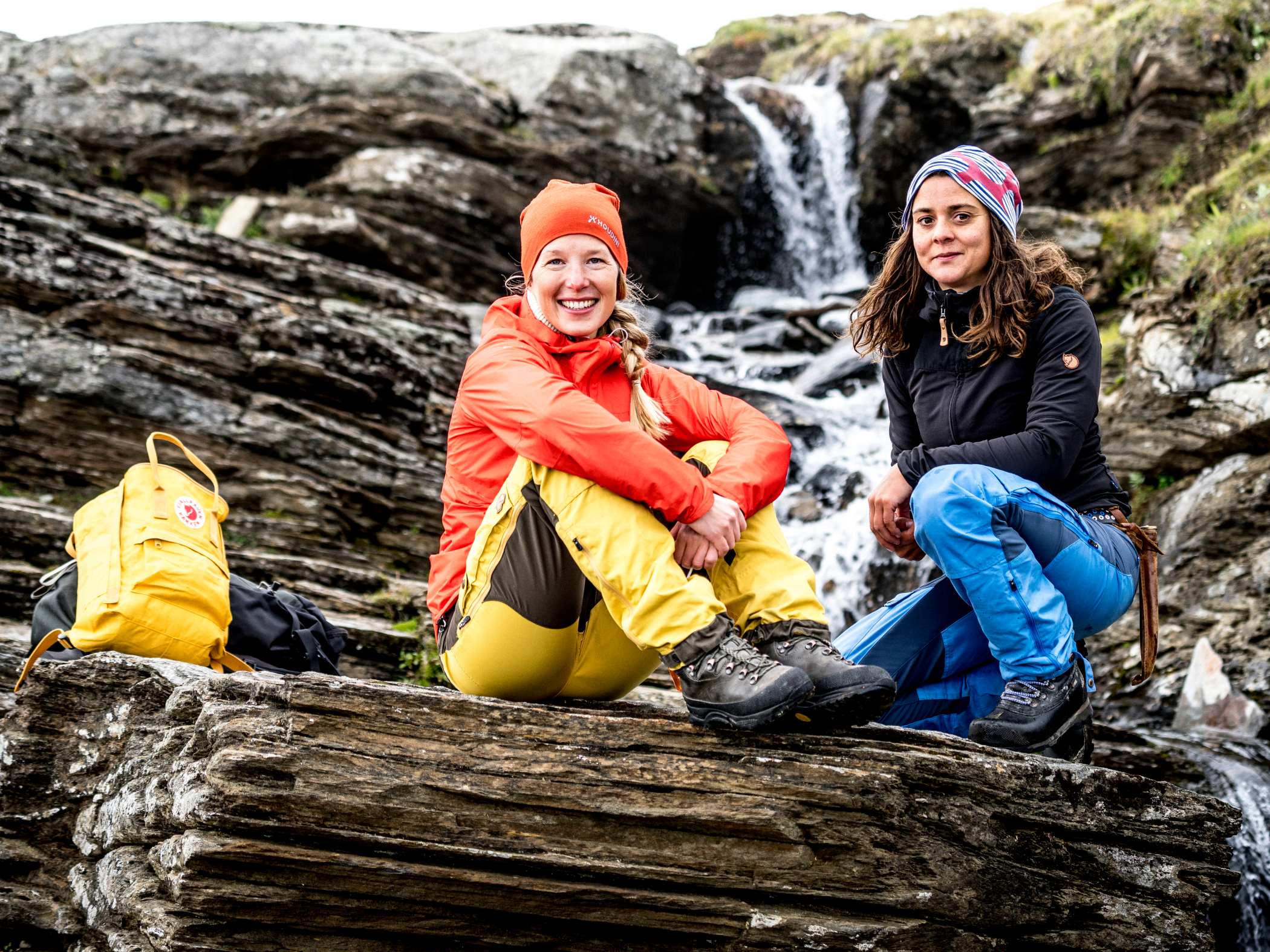 Två vandrare har paus vid ett vattenfall.