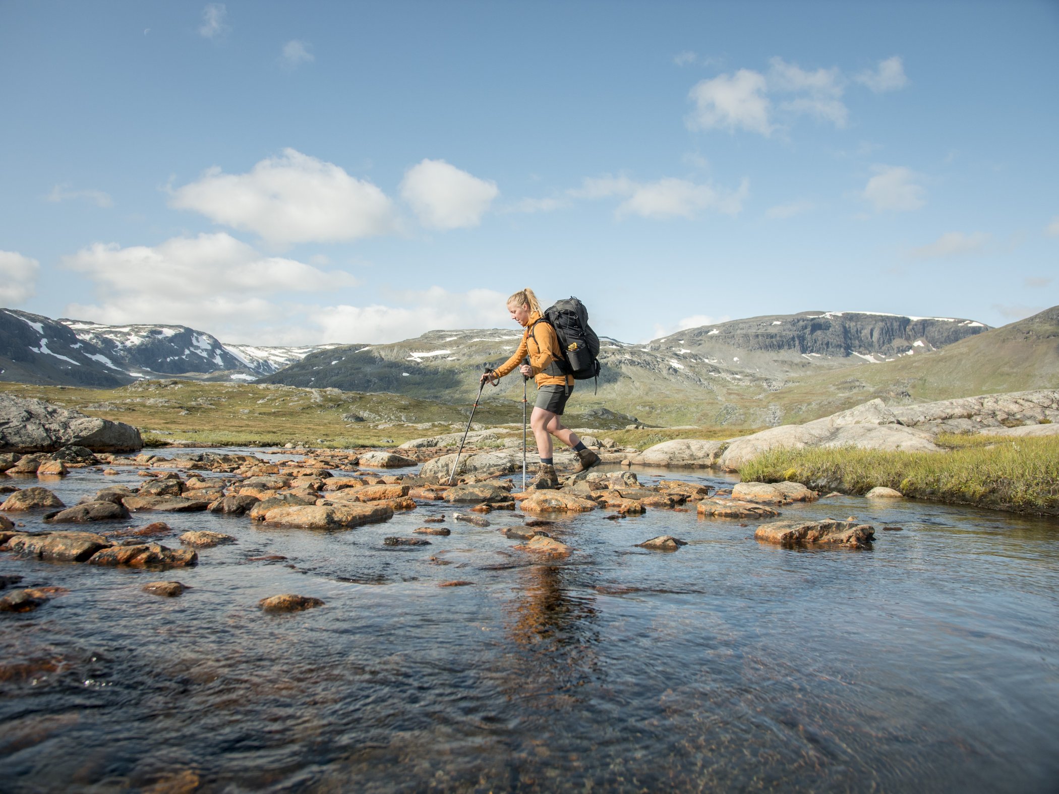 Fjällvandrare som vadar på Kungsleden.