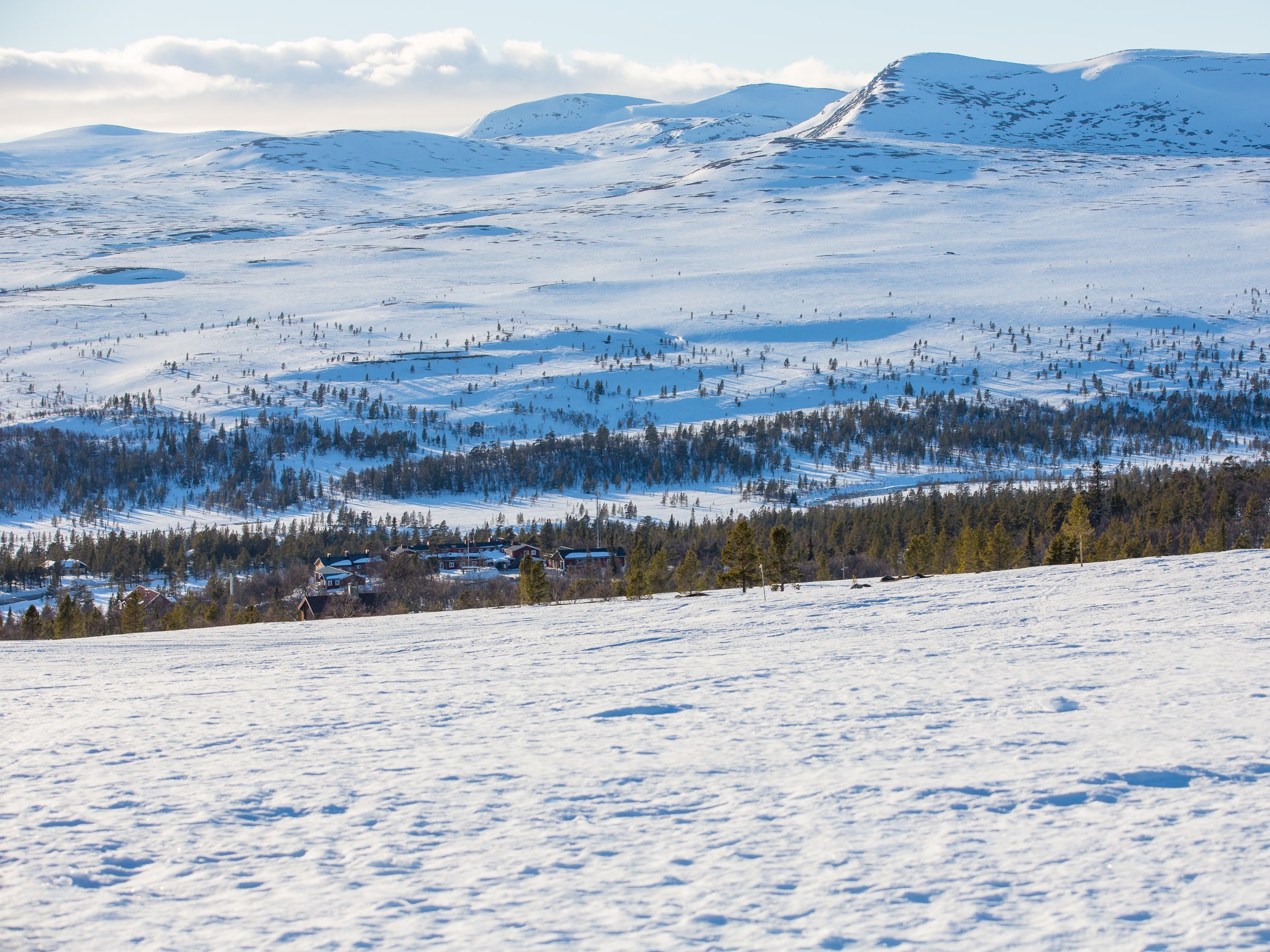 Flygbild över fjäll med snö.