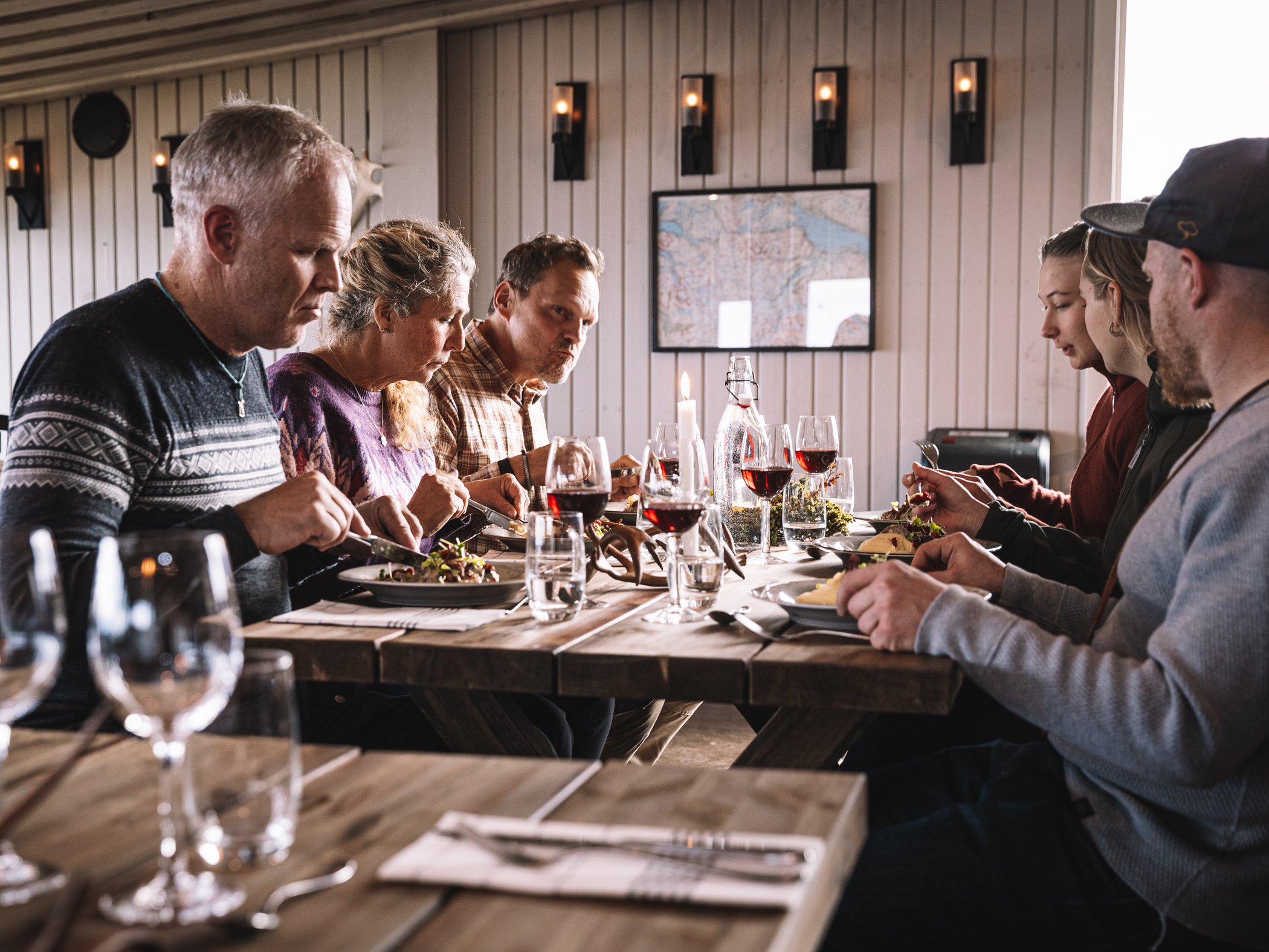 Gäster äter middag tillsammans i restaurangen på STF Abisko Fjällstation.