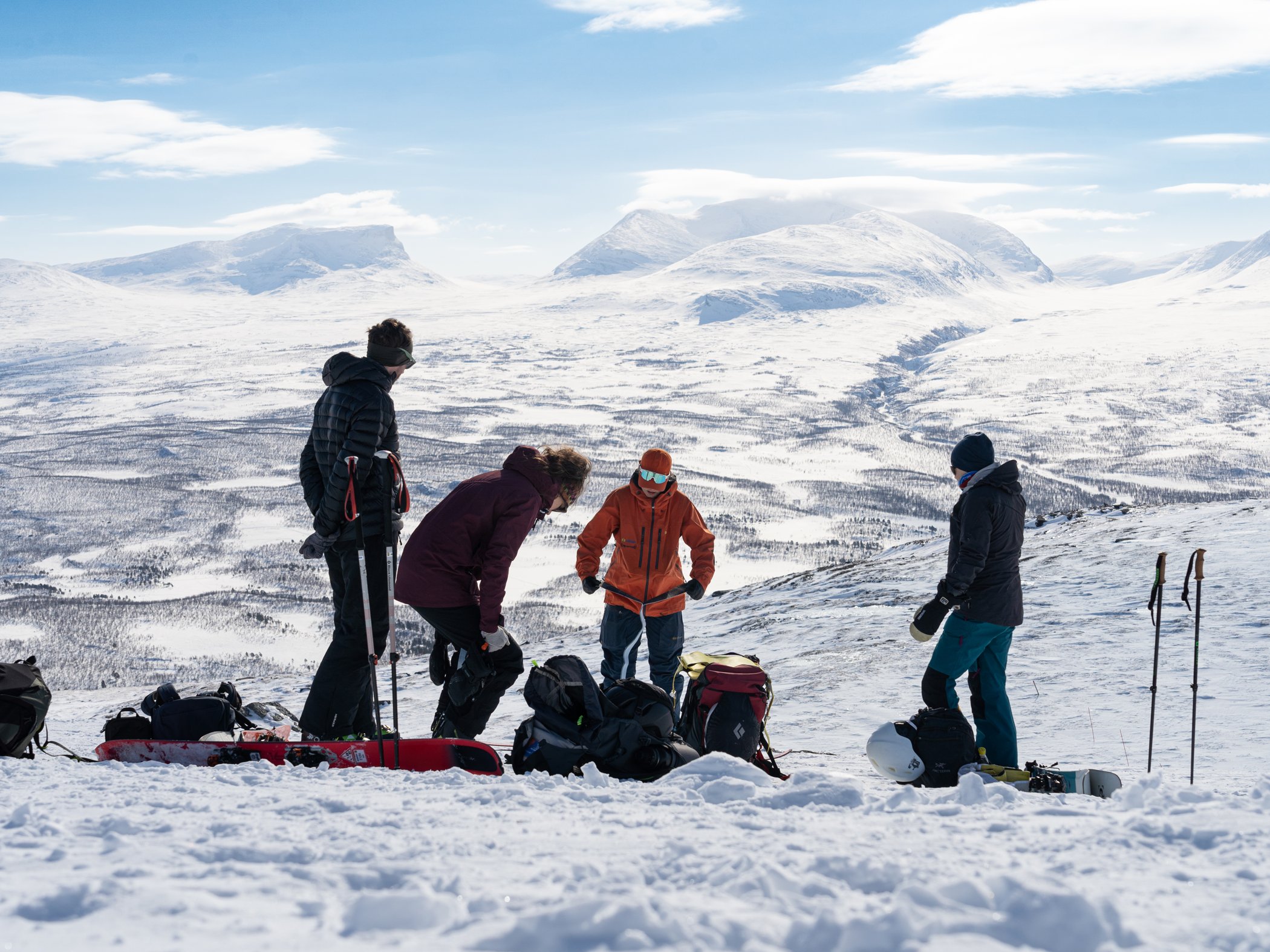 Grupp förbereder sig för topptur med utsikt över det snötäckta fjällandskapet i Abisko.